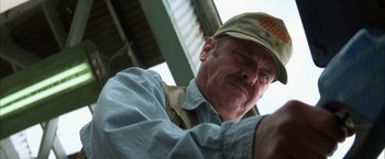 Movie still from “The Pledge” (2001), directed by Sean Penn – An older man wearing a hat and a blue shirt; Close Up shot, Low angle