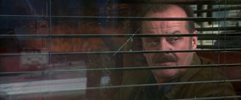 Movie still from “The Pledge” (2001), directed by Sean Penn – A man with a mustache looking out of a window; Close Up shot, Over the shoulder angle