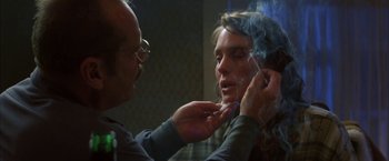 Movie still from “The Pledge” (2001), directed by Sean Penn – A man putting makeup on a woman's face; Close Up shot, Over the shoulder angle