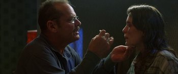 Movie still from “The Pledge” (2001), directed by Sean Penn – Two men are talking to each other while holding a cigarette; Close Up shot, Over the shoulder angle