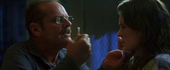 Movie still from “The Pledge” (2001), directed by Sean Penn – A man with glasses is holding a toothbrush in his mouth while another man with glasses is holding a toothbrush in his mouth; Close Up shot, Over the shoulder angle