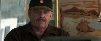 Movie still from “The Pledge” (2001), directed by Sean Penn – An older man wearing a baseball cap looking at a computer screen; Close Up shot, Over the shoulder angle
