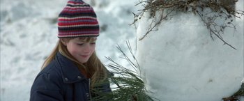 Movie still from “The Pledge” (2001), directed by Sean Penn – A young girl holding a plant in her hands; Close Up shot, Over the shoulder angle