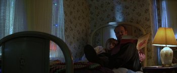 Movie still from “The Pledge” (2001), directed by Sean Penn – A man and a little girl sitting on a bed; Medium shot, Low angle