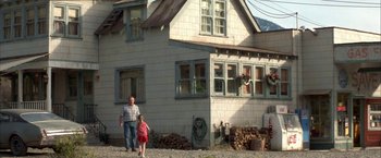 Movie still from “The Pledge” (2001), directed by Sean Penn – A man and a little girl standing in front of a house; Wide shot, Low angle