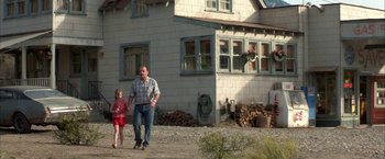 Movie still from “The Pledge” (2001), directed by Sean Penn – A man and a little girl walking in front of a house; Wide shot, Low angle