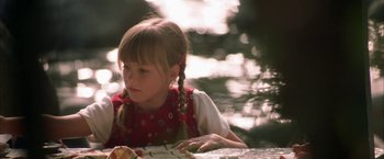 Movie still from “The Pledge” (2001), directed by Sean Penn – A little girl sitting at a table in a forest; Close Up shot, High angle