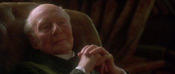 Movie still from “The Portrait of a Lady” (1996), directed by Jane Campion – An older man sitting in a chair holding his hands; Close Up shot, Low angle