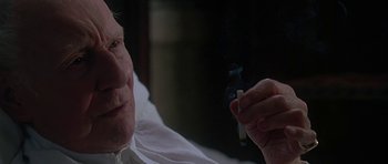 Movie still from “The Portrait of a Lady” (1996), directed by Jane Campion – An older man smoking a cigarette in a dark room; Close Up shot, Over the shoulder angle
