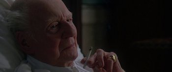 Movie still from “The Portrait of a Lady” (1996), directed by Jane Campion – An older man smoking a cigarette in a dark room; Close Up shot, Over the shoulder angle