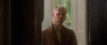 Movie still from “The Portrait of a Lady” (1996), directed by Jane Campion – A man with a bald head wearing a brown jacket; Close Up shot, Low angle