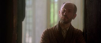 Movie still from “The Portrait of a Lady” (1996), directed by Jane Campion – A man with a bald head wearing a sweater; Close Up shot, Low angle