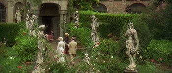 Movie still from “The Portrait of a Lady” (1996), directed by Jane Campion – A group of people standing in a garden with statues; Extreme Wide shot, High angle