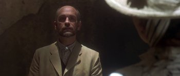 Movie still from “The Portrait of a Lady” (1996), directed by Jane Campion – A man wearing a suit and tie standing in front of a mirror; Close Up shot, Low angle