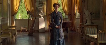 Movie still from “The Portrait of a Lady” (1996), directed by Jane Campion – A woman standing in front of a piano in a living room; Wide shot, Low angle