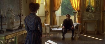 Movie still from “The Portrait of a Lady” (1996), directed by Jane Campion – Two men and a woman sitting on a couch in a room; Wide shot, Over the shoulder angle