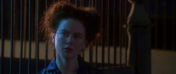 Movie still from “The Portrait of a Lady” (1996), directed by Jane Campion – A young woman with large hair in front of a fence; Close Up shot, Over the shoulder angle