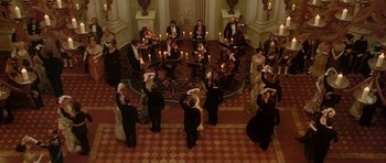 Movie still from “The Portrait of a Lady” (1996), directed by Jane Campion – A group of people in formal wear standing around a table; Extreme Wide shot, High angle