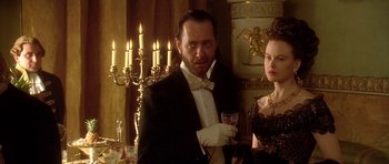 Movie still from “The Portrait of a Lady” (1996), directed by Jane Campion – A man and a woman standing next to each other in front of candles; Medium shot, Over the shoulder angle