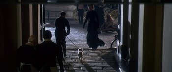 Movie still from “The Portrait of a Lady” (1996), directed by Jane Campion – A woman walking a dog down a set of stairs; Wide shot, High angle