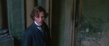 Movie still from “The Portrait of a Lady” (1996), directed by Jane Campion – A man in a suit standing in front of a wall; Close Up shot, High angle