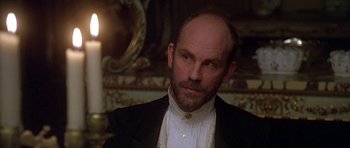 Movie still from “The Portrait of a Lady” (1996), directed by Jane Campion – A man with a beard and mustache wearing a black suit and white shirt; Close Up shot, Over the shoulder angle