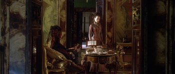 Movie still from “The Portrait of a Lady” (1996), directed by Jane Campion – A woman standing in front of a mirror in a room; Wide shot, Over the shoulder angle