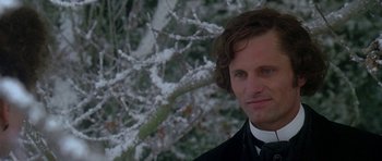 Movie still from “The Portrait of a Lady” (1996), directed by Jane Campion – A person wearing a suit near a tree; Close Up shot, Over the shoulder angle