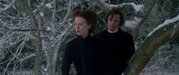 Movie still from “The Portrait of a Lady” (1996), directed by Jane Campion – A man and a woman standing next to each other in front of a tree; Medium shot, Low angle