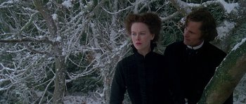 Movie still from “The Portrait of a Lady” (1996), directed by Jane Campion – A woman standing in front of a tree in the snow; Medium shot, Low angle