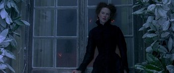 Movie still from “The Portrait of a Lady” (1996), directed by Jane Campion – A woman standing in front of a window in the dark; Medium shot, Over the shoulder angle