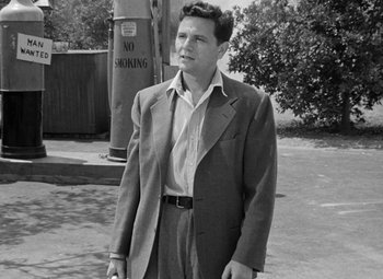Movie still from “The Postman Always Rings Twice” (1946), directed by Tay Garnett – A black and white photo of a man in a suit; Medium shot, Low angle