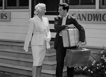 Movie still from “The Postman Always Rings Twice” (1946), directed by Tay Garnett – A man and a woman standing next to each other holding suitcases; Medium shot, Over the shoulder angle