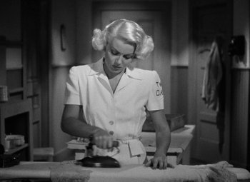 Movie still from “The Postman Always Rings Twice” (1946), directed by Tay Garnett – A black and white photo of a woman ironing clothes; Medium shot, High angle