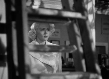 Movie still from “The Postman Always Rings Twice” (1946), directed by Tay Garnett – A black - and - white photo of a woman looking in a mirror; Medium shot, Low angle