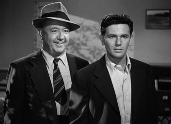 Movie still from “The Postman Always Rings Twice” (1946), directed by Tay Garnett – Two men in suits and hats posing for a picture; Medium shot, Low angle