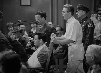 Movie still from “The Postman Always Rings Twice” (1946), directed by Tay Garnett – A group of men sitting in front of each other in a courtroom; Medium shot, Low angle