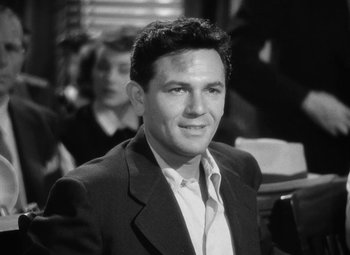 Movie still from “The Postman Always Rings Twice” (1946), directed by Tay Garnett – Black and white photograph of a man in a suit; Medium shot, High angle