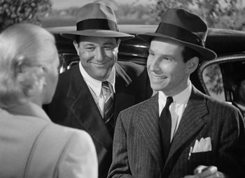 Movie still from “The Postman Always Rings Twice” (1946), directed by Tay Garnett – A couple of men standing next to each other in a car; Medium shot, Over the shoulder angle