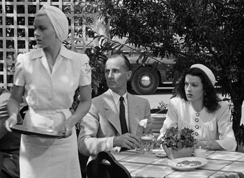 Movie still from “The Postman Always Rings Twice” (1946), directed by Tay Garnett – A man and two women sitting at a table; Medium shot, Over the shoulder angle