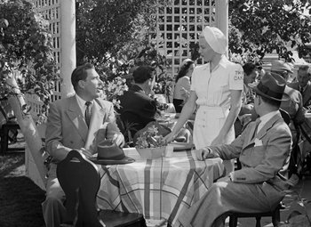 Movie still from “The Postman Always Rings Twice” (1946), directed by Tay Garnett – A group of people sitting around a table; Medium shot, Over the shoulder angle