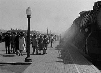 Movie still from “The Postman Always Rings Twice” (1946), directed by Tay Garnett – A black and white photo of a crowd of people waiting to board a train; Extreme Wide shot, Low angle