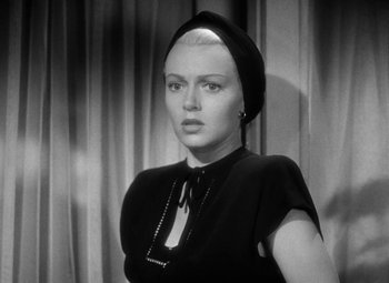 Movie still from “The Postman Always Rings Twice” (1946), directed by Tay Garnett – A black and white photo of a woman wearing a head scarf; Close Up shot, Low angle