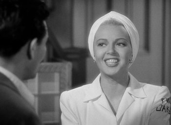 Movie still from “The Postman Always Rings Twice” (1946), directed by Tay Garnett – A black - and - white photo of a woman in a turban; Close Up shot, Over the shoulder angle