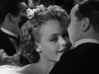 Movie still from “The Pride of the Yankees” (1942), directed by Sam Wood – A woman with a bow in her hair and a man in a suit; Close Up shot, Over the shoulder angle