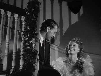 Movie still from “The Pride of the Yankees” (1942), directed by Sam Wood – A man and a woman are smiling for the camera; Medium shot, Low angle