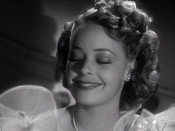 Movie still from “The Pride of the Yankees” (1942), directed by Sam Wood – A black - and - white photo of a woman smiling; Close Up shot, Low angle