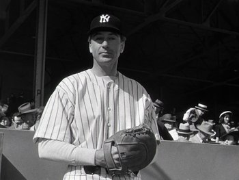 Movie still from “The Pride of the Yankees” (1942), directed by Sam Wood – A baseball player holding a catchers mitt in front of a group of people; Medium shot, Low angle