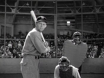 Movie still from “The Pride of the Yankees” (1942), directed by Sam Wood – A baseball player is posing for a picture in front of a crowd; Medium shot, Low angle