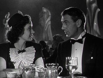 Movie still from “The Pride of the Yankees” (1942), directed by Sam Wood – A man and a woman sitting at a dinner table; Medium shot, Over the shoulder angle